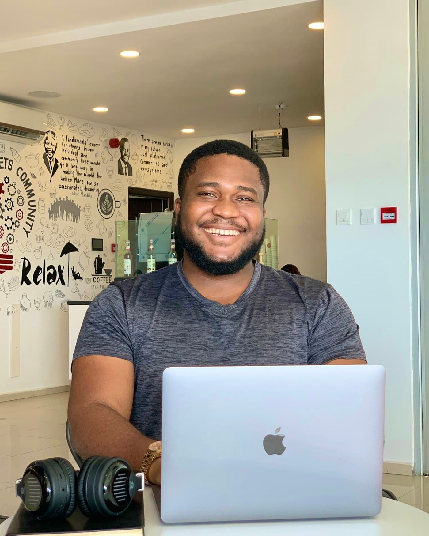 An analyst smiling behind an open laptop in a bright office